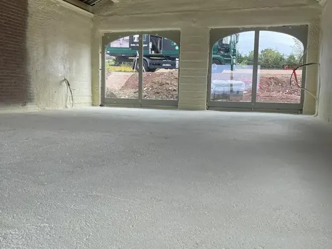 Murs en briques isolés par l'intérieur à la mousse polyuréthane projetée, sous charpente apparente