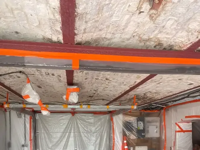 Garage préparé avant la projection de mousse polyuréthane : porte, murs et équipements bâchés